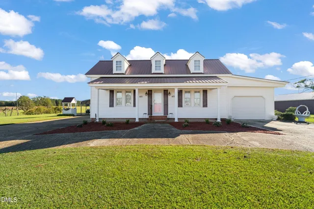 a front view of a house with a garden and yard
