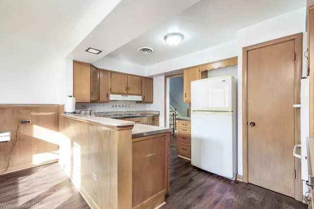 a kitchen with a refrigerator a stove top oven a sink and a counter top space