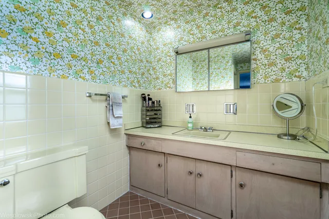 a bathroom with a toilet sink and mirror