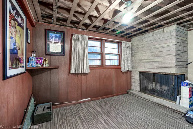 a view of an empty room with wooden floor and a fireplace