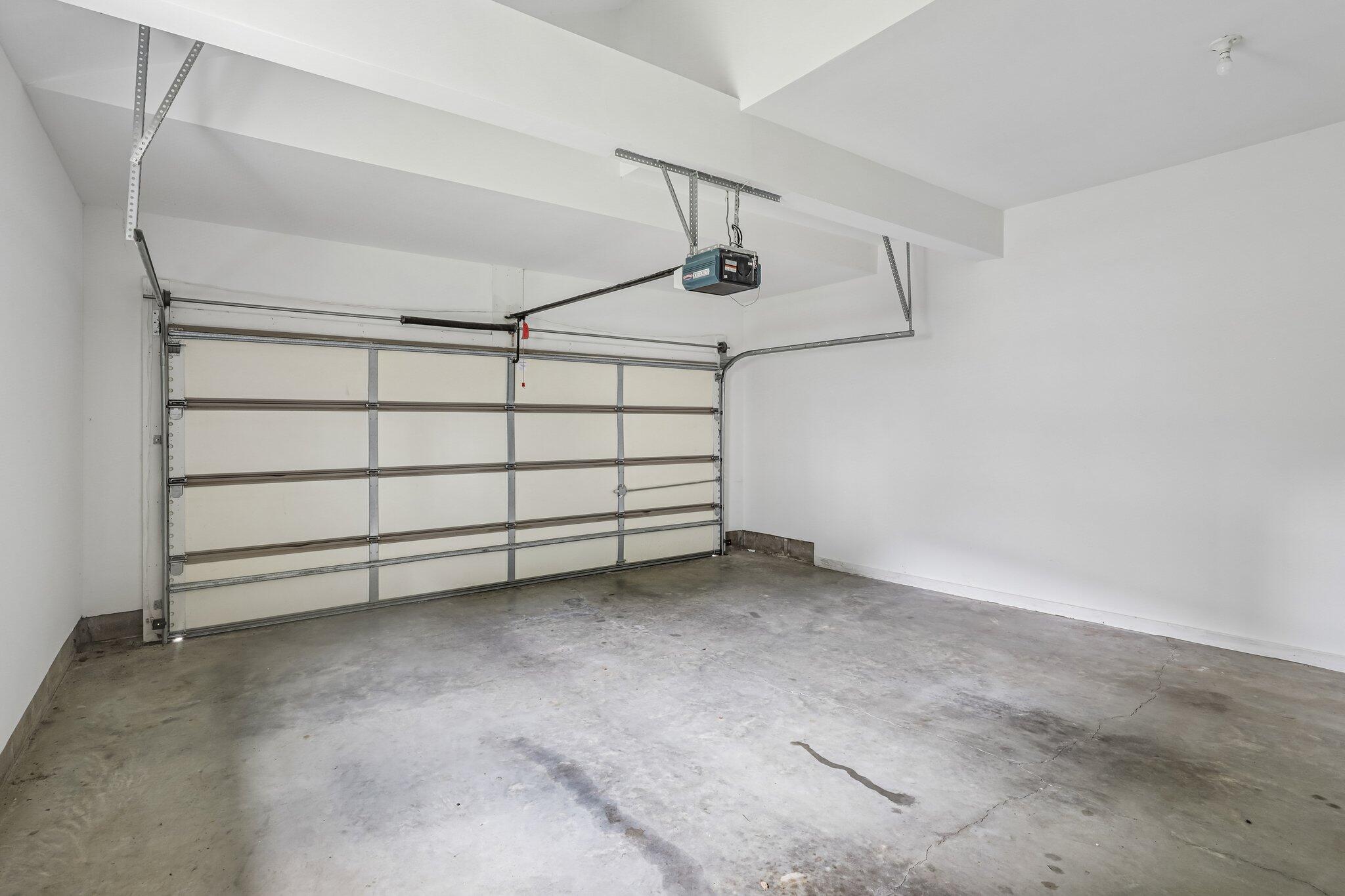876 Flint Ridge Newport, KY 41076 - Photo 39 of 43 Garage interior featuring a sectional garage door, concrete flooring, overhead garage door opener, and white painted walls