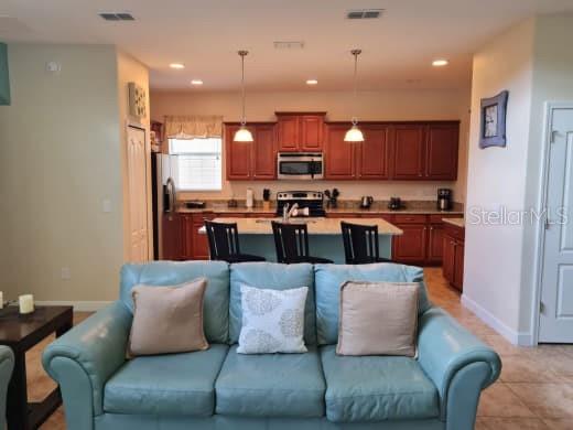 8923 Cuban Palm Road Kissimmee, FL 34747 - Photo 19 of 87 a living room with stainless steel appliances kitchen island granite countertop a couch and a view of kitchen