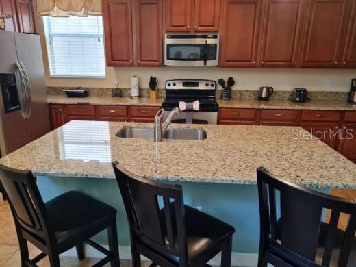 8923 Cuban Palm Road Kissimmee, FL 34747 - Photo 21 of 87 a kitchen with granite countertop cabinets stainless steel appliances and a counter space