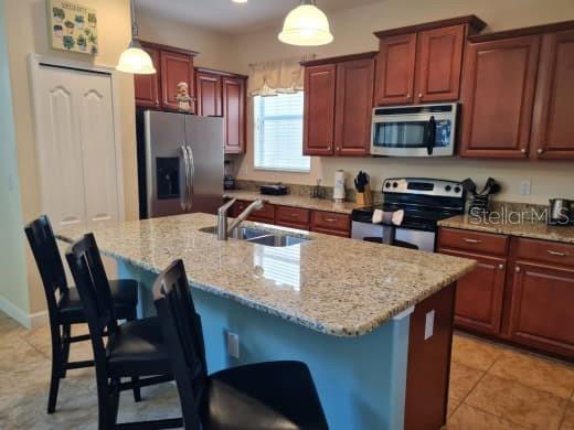 8923 Cuban Palm Road Kissimmee, FL 34747 - Photo 22 of 87 a kitchen with stainless steel appliances granite countertop a table chairs microwave and refrigerator
