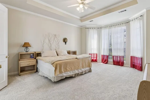 a spacious bedroom with a bed and a chandelier