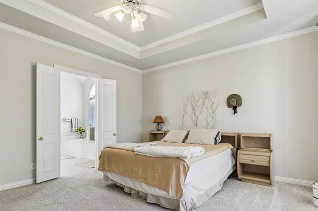 a bedroom with a large bed and a chandelier