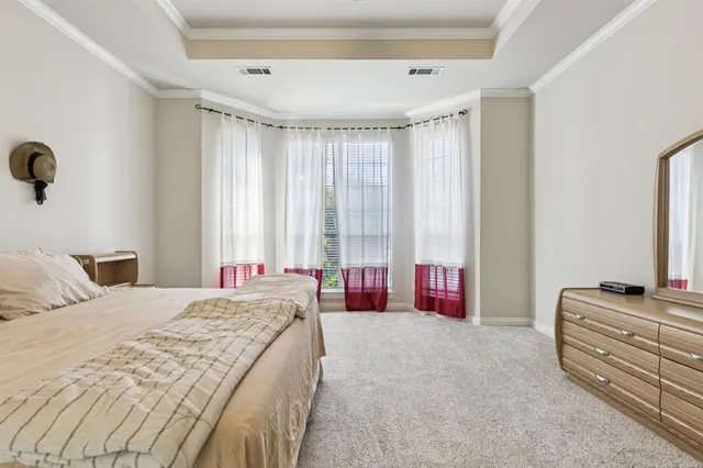 a spacious bedroom with a bed and a dresser