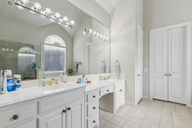 a spacious en suite bathroom with a double vanity sink and a mirror