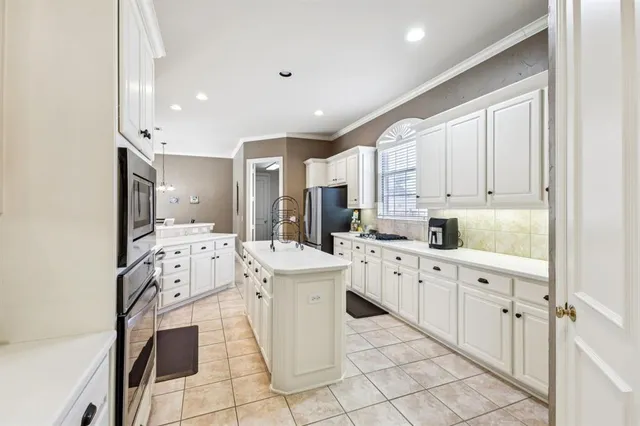 a large white kitchen with cabinets