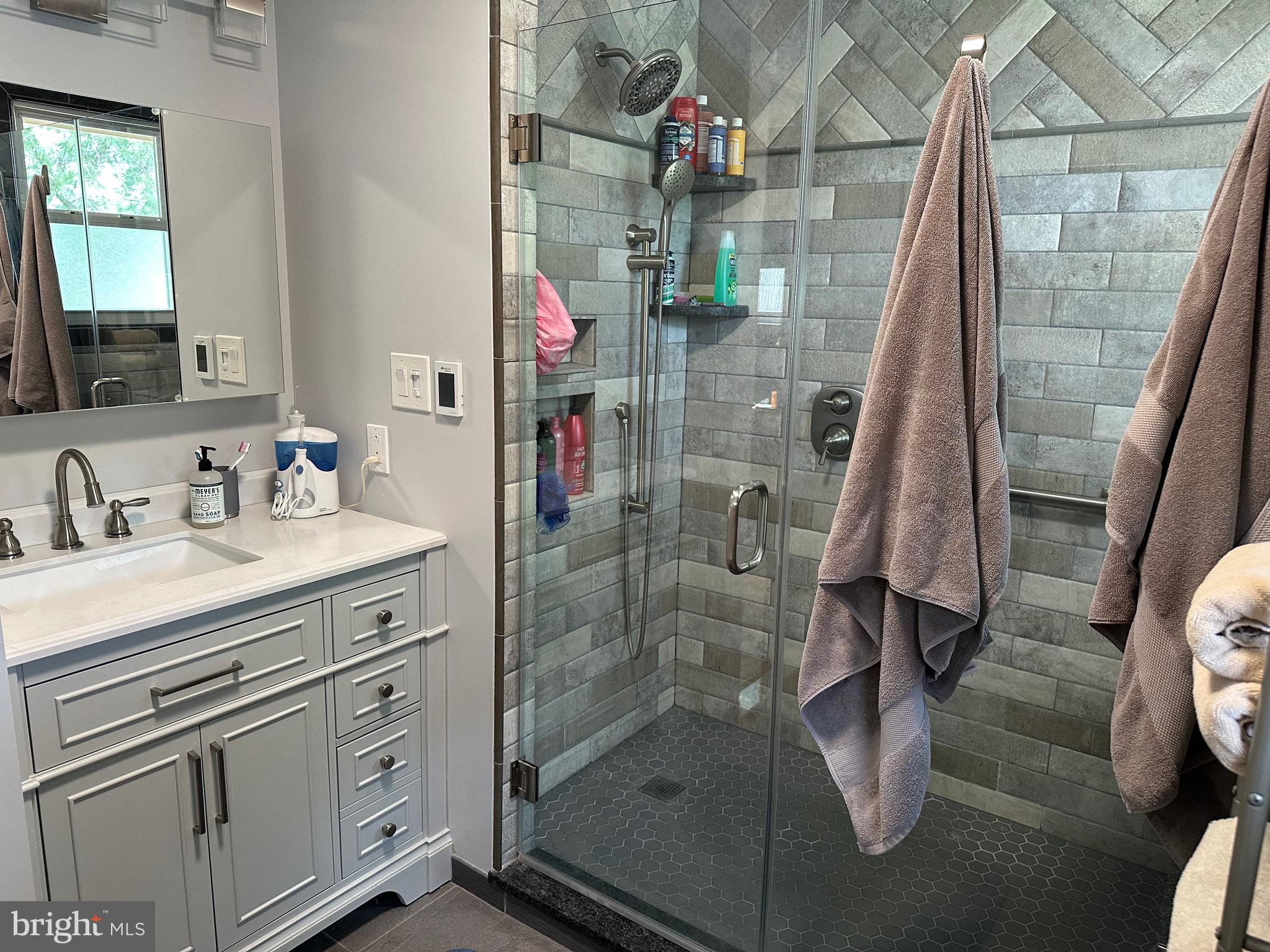 901 Kingston Drive Cherry Hill, NJ 08034 - Photo 18 of 30 a bathroom with a shower sink and mirror