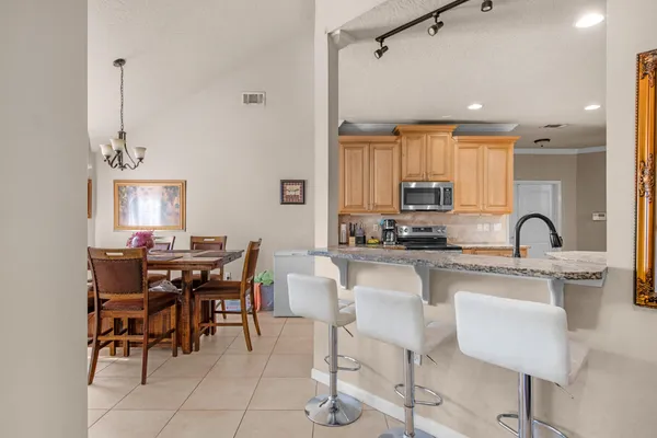 a kitchen with kitchen island granite countertop a table and chairs in it