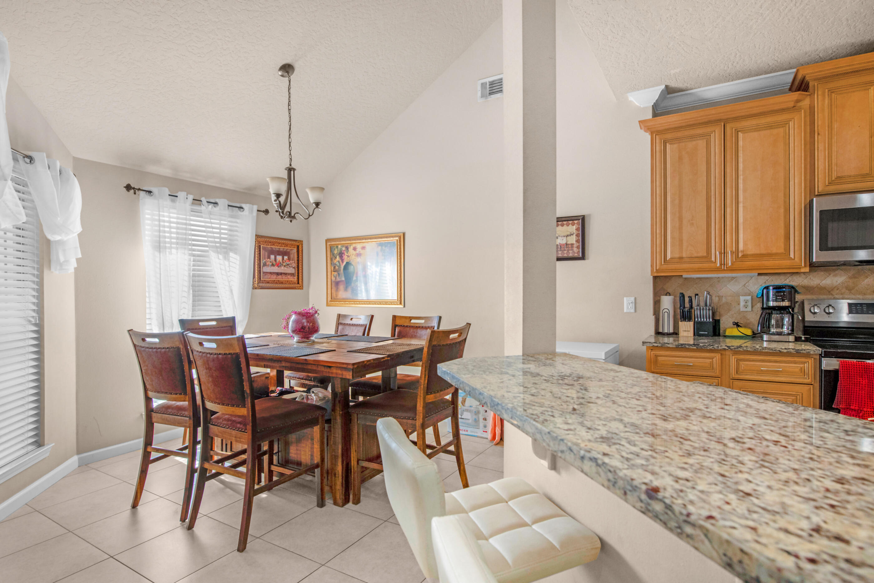 4537 Annabelle Lane Crestview, FL 32539 - Photo 12 of 41 a kitchen with stainless steel appliances granite countertop a stove top oven a sink a dining table and chairs with white cabinets