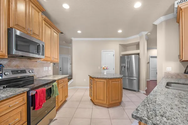 a kitchen with stainless steel appliances granite countertop a stove a sink and a refrigerator