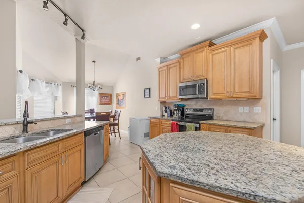 a kitchen with stainless steel appliances granite countertop a sink stove and microwave