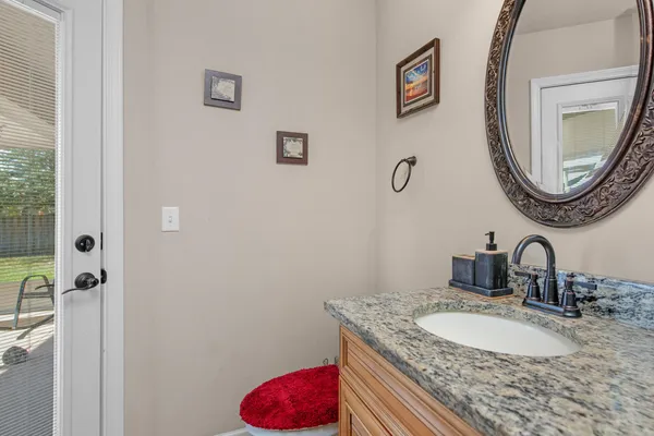 a bathroom with a granite countertop sink a mirror and vanity
