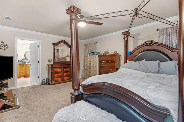 a bedroom with a bed a dresser and flat screen tv