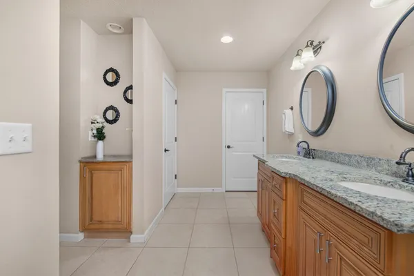 a spacious bathroom with a granite countertop sink a mirror and a shower