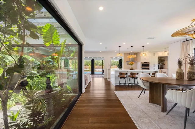 a kitchen with stainless steel appliances kitchen island granite countertop a table chairs and a refrigerator