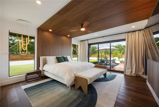 a bedroom with a large bed and a flat tv screen