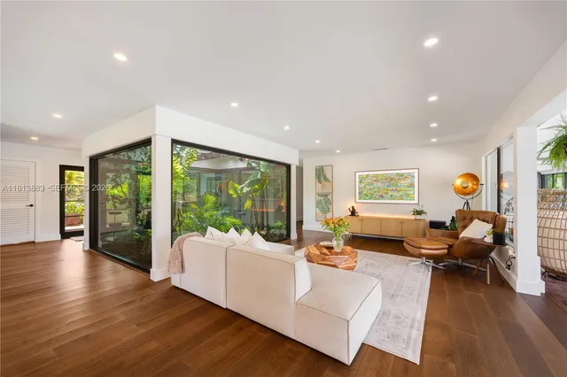 a living room with fireplace furniture and a large window