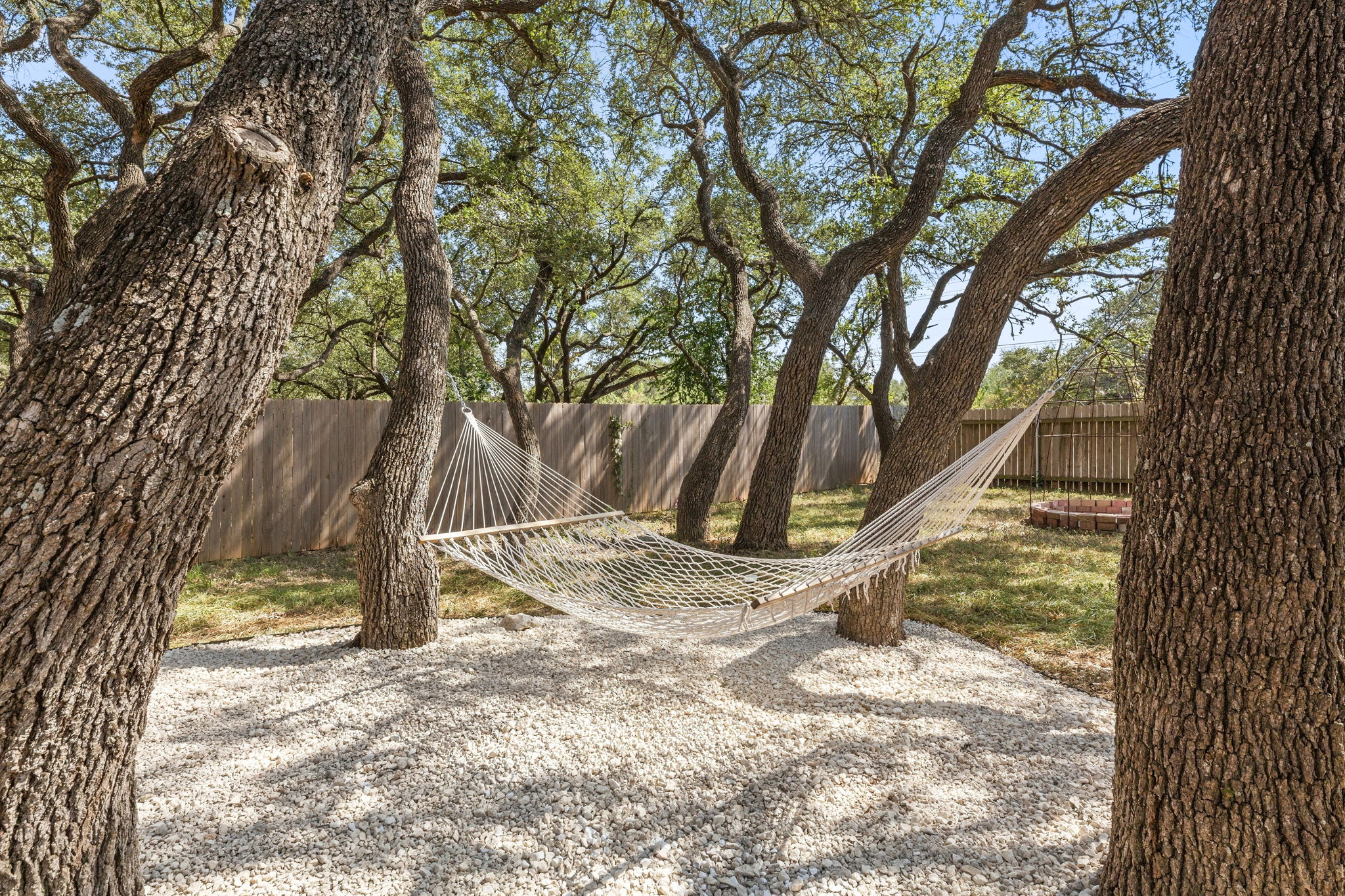 4609 Walsall Loop Austin, TX 78749 - Photo 35 of 39 Mature shade trees and a gravel terrace create a serene retreat within the fenced backyard.