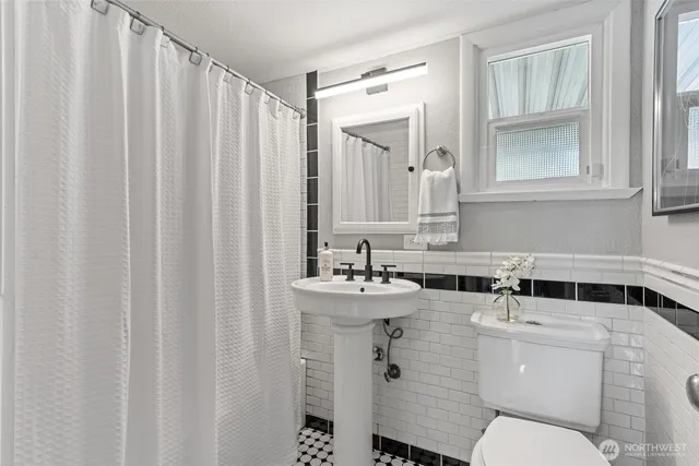a bathroom with a sink mirror and toilet