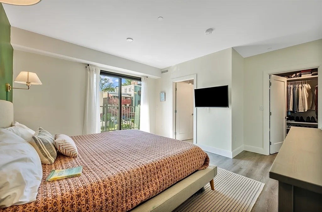 765 East 3rd Street, Unit 201 Boston, MA 02127 - Photo 4 of 10 a bedroom with a large bed and a flat screen tv
