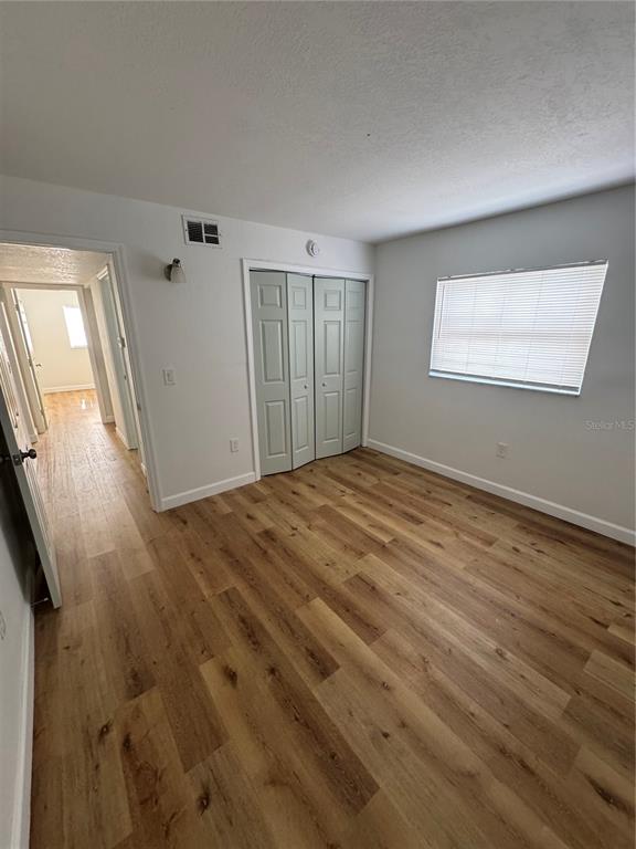 9831 Aquarius Drive, Unit 7 Port Richey, FL 34668 - Photo 11 of 16 a view of an empty room with wooden floor and a window