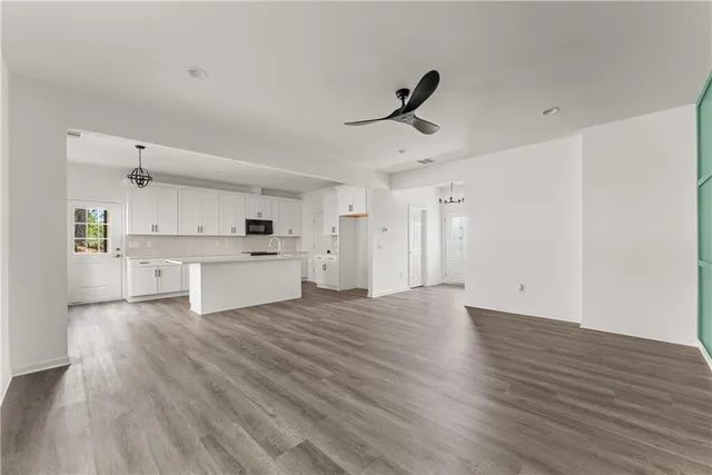 a view of an empty room with window and wooden floor
