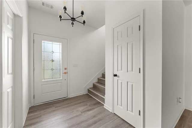 a view of a hallway with wooden floor and entryway