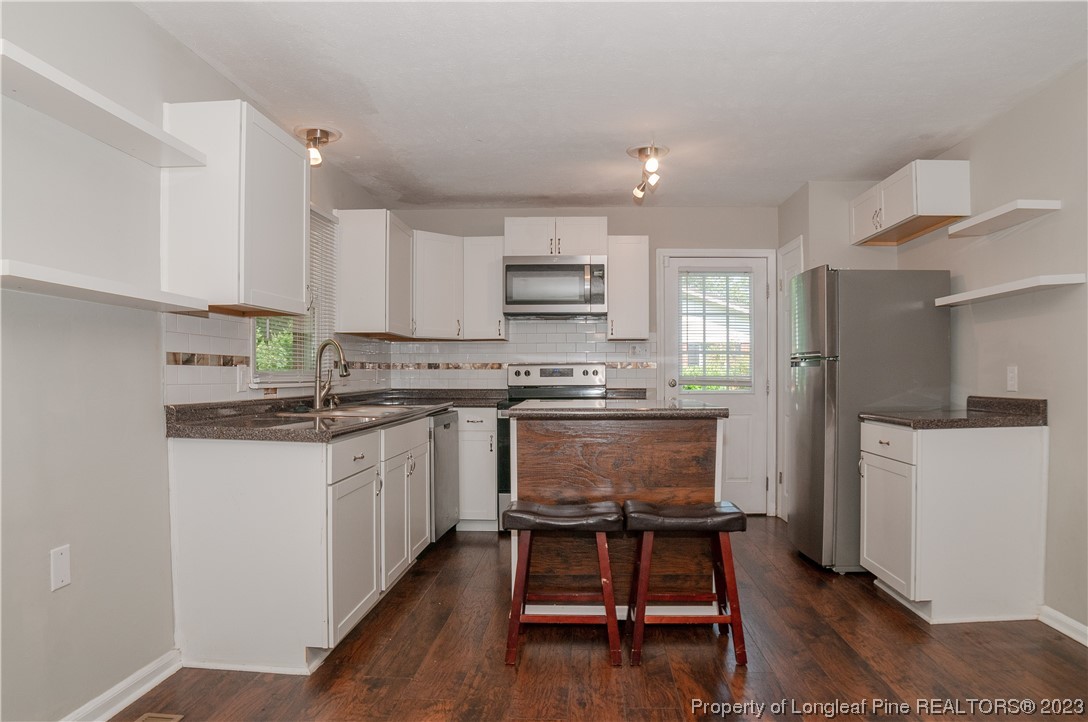 4605 Nix Road Fayetteville, NC 28314 - Photo 22 of 48 a kitchen with kitchen island a white counter top space a sink stainless steel appliances and cabinets