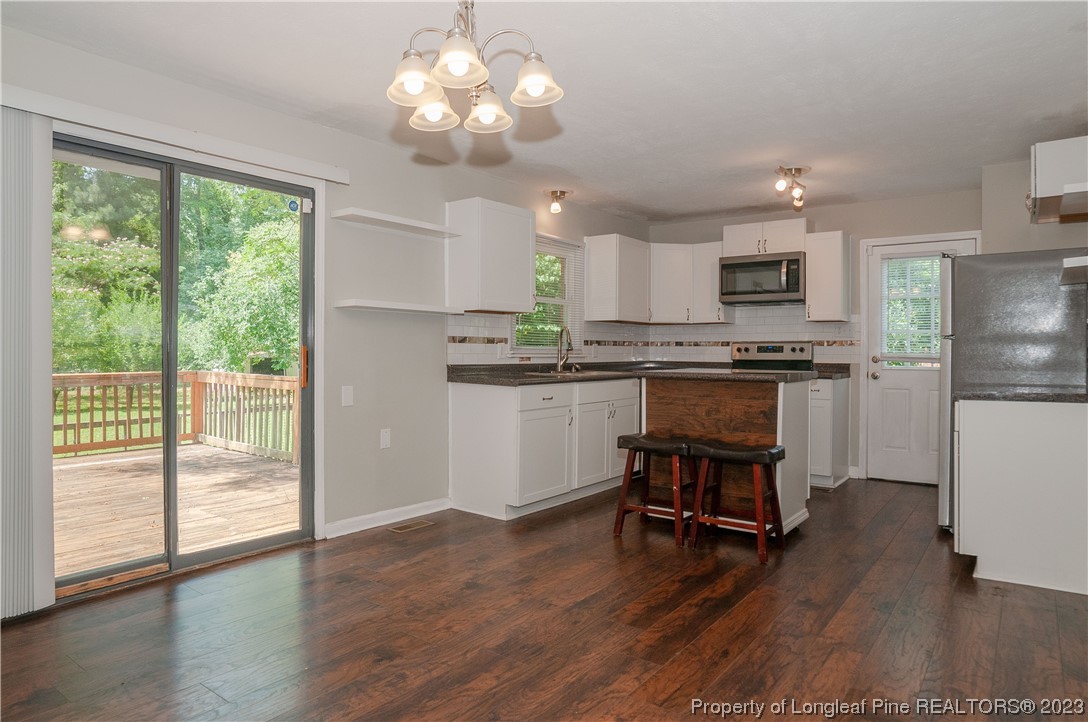 4605 Nix Road Fayetteville, NC 28314 - Photo 24 of 48 a kitchen with kitchen island hardwood floor and a view of dining room