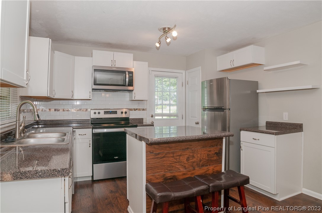 4605 Nix Road Fayetteville, NC 28314 - Photo 26 of 48 a kitchen with kitchen island a counter space a sink appliances and cabinets
