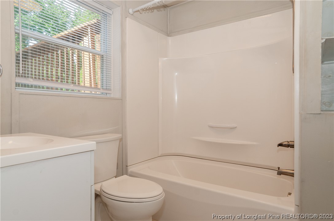4605 Nix Road Fayetteville, NC 28314 - Photo 33 of 48 a bathroom with a granite countertop toilet a sink and a bathtub