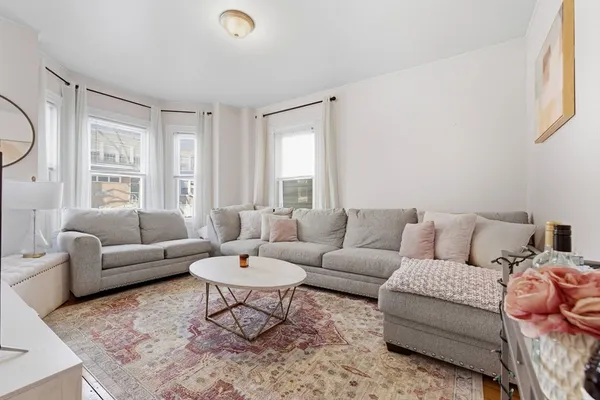 a living room with furniture a rug and a window
