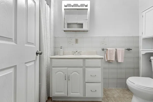 a bathroom with a sink toilet and mirror