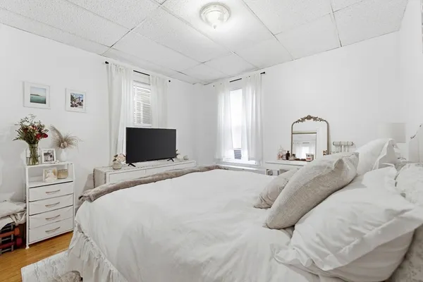 a bedroom with a bed and wooden floor