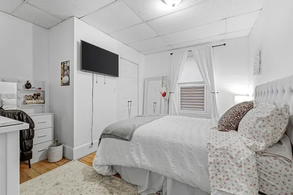 a bedroom with a bed a flat screen tv and a couch