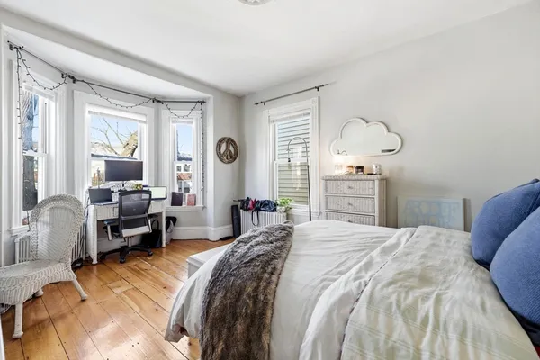 a bedroom with a bed couch and a large window