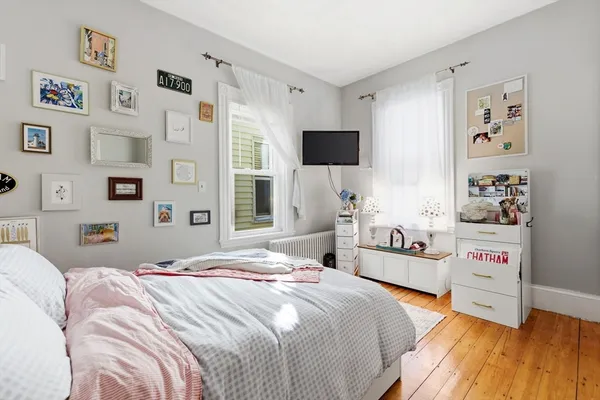 a bedroom with a bed and a wooden floor