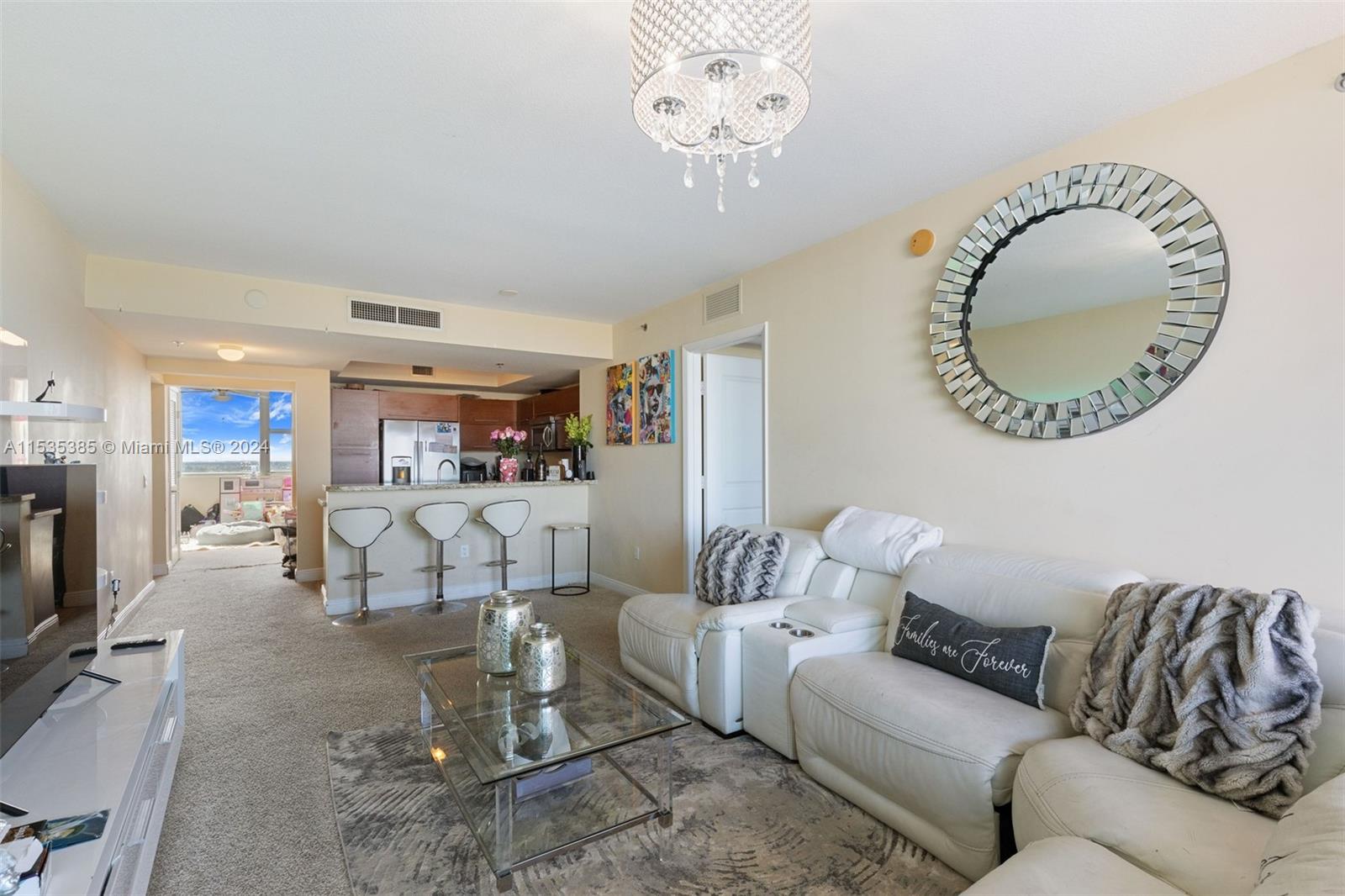 2681 North Flamingo Road, Unit 1405S Sunrise, FL 33323 - Photo 6 of 28 a living room with furniture a fireplace and a chandelier