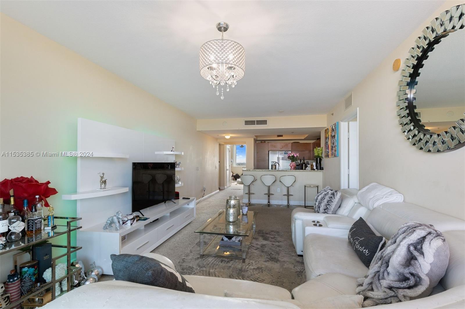 2681 North Flamingo Road, Unit 1405S Sunrise, FL 33323 - Photo 7 of 28 a living room with furniture a flat screen tv and a large window