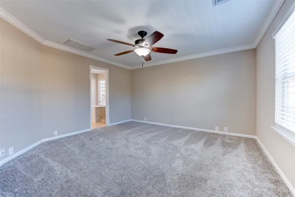 an empty room with a window and a fan