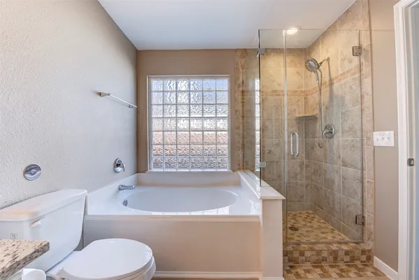 a bathroom with a granite countertop toilet sink and bathtub