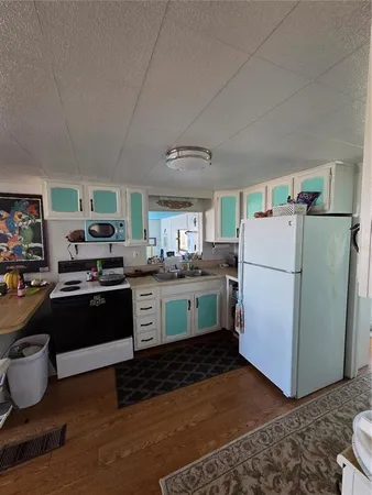 a kitchen with a refrigerator and a stove top oven