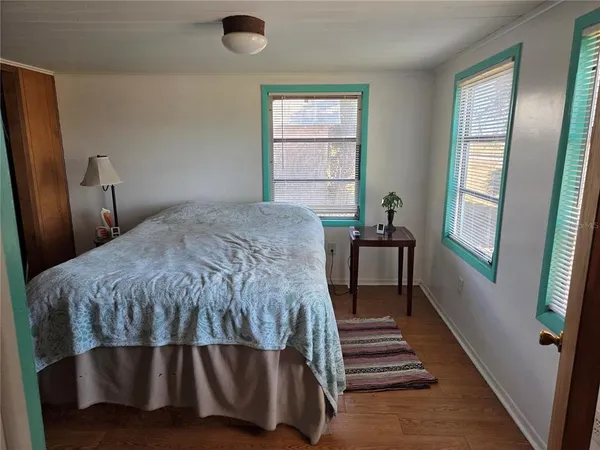 a bedroom with a bed and wooden floor