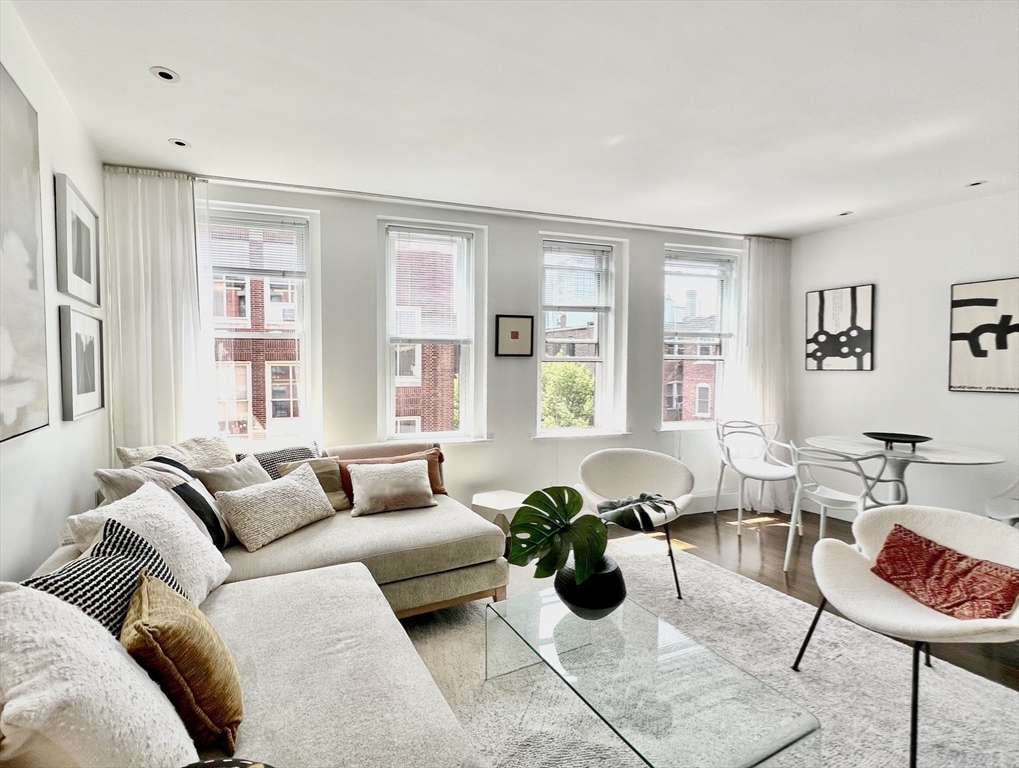 a living room with furniture potted plant and windows