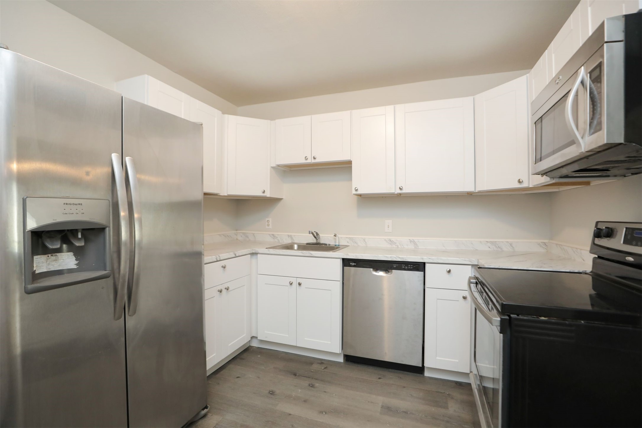 2814 Winbern Street Houston, TX 77004 - Photo 6 of 21 a kitchen with stainless steel appliances granite countertop a refrigerator a sink and white cabinets