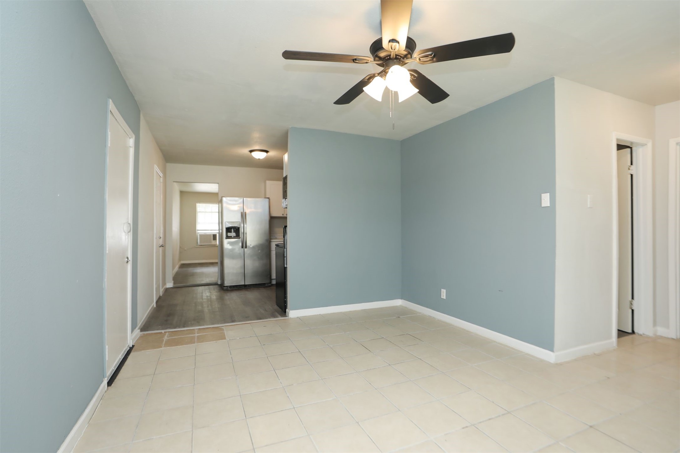 2814 Winbern Street Houston, TX 77004 - Photo 7 of 21 a view of a big room with a chandelier fan and a bathroom