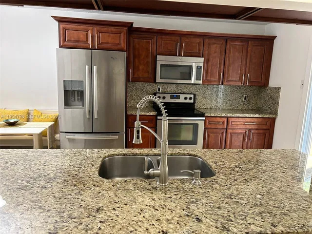 a kitchen with a refrigerator and windows